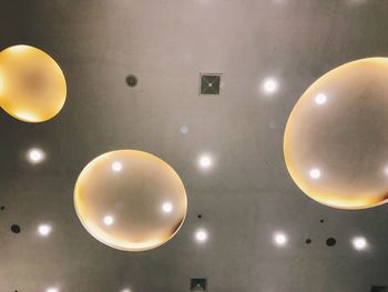 Low angle view of illuminated lighting equipment hanging on ceiling