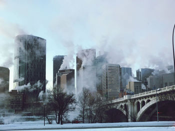 Buildings in city against sky during winter