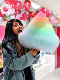 Young woman eating cotton candy 