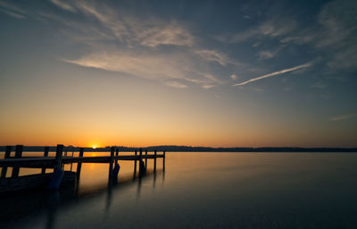 Pier over sea against sky during sunset