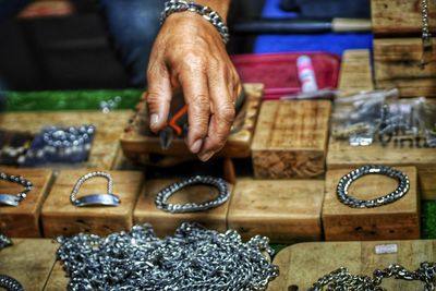 Cropped hand choosing jewelry