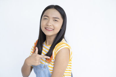 Portrait of smiling young woman against white background