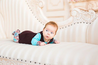 Portrait of cute boy lying on bed