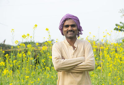 Happy indian farmer standing in agricultural field