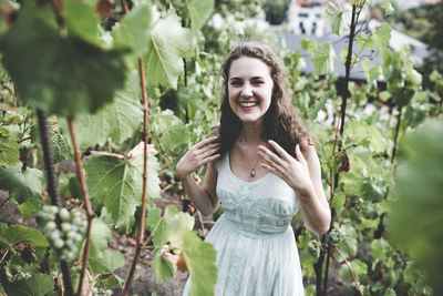 Beautiful curly hair young woman in a light blue simple dress in a vineyard. end of the summer 