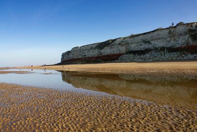 Scenic view of beach against clear blue sky