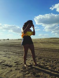 Full length of woman standing on landscape against sky