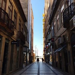 People walking on road along built structures