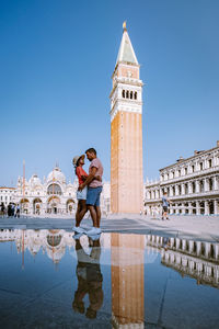 Reflection of people on building against clear sky