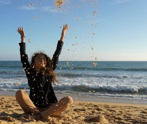 Rear view of woman enjoying at beach