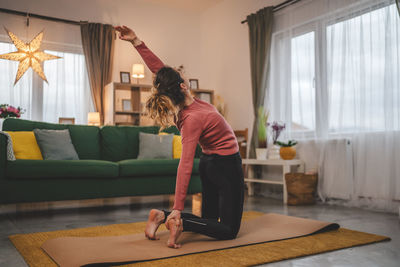 Portrait of young woman sitting on floor at home