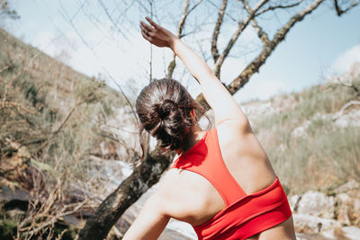 Rear view of woman standing against trees