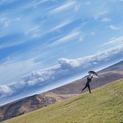 Full length of woman walking on field against sky