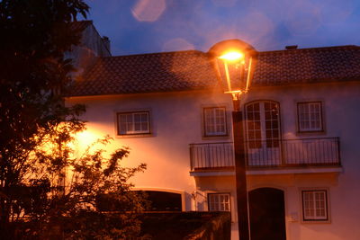 Low angle view of illuminated building at sunset