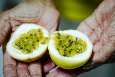 Close-up of hand holding passion fruit