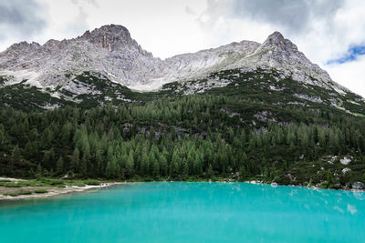 Scenic view of lake by mountains against sky