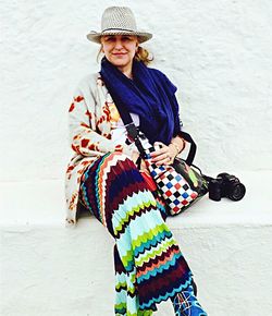 Portrait of woman wearing hat while standing against wall