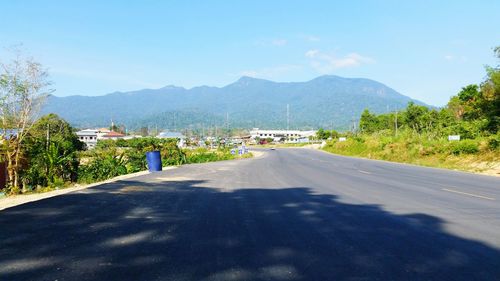 Road by mountains against clear sky