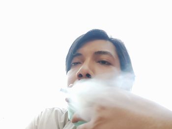 Close-up portrait of young man against white background