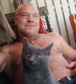 Portrait of man sitting with cat at home