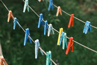 Close-up of multi colored clothespins hanging on rope