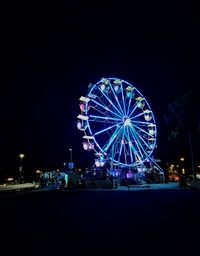 Illuminated ferris wheel at night