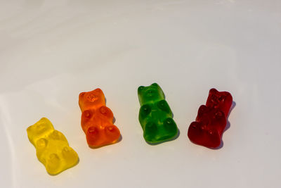 High angle view of multi colored candies against white background