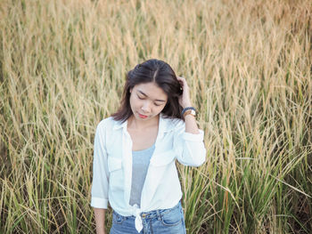 Smiling young woman standing on field