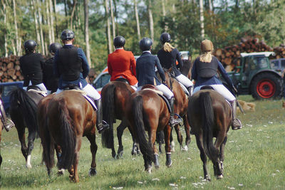 People riding horses on field at fuchsjagd 