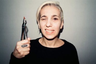 Portrait of young woman holding camera