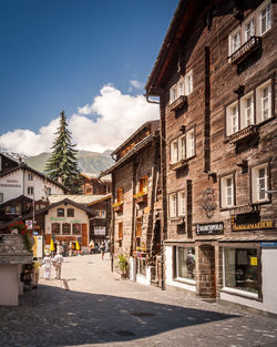 Street by buildings in city against sky