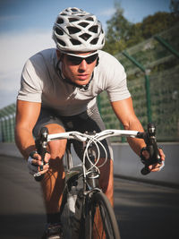 Full length of man riding bicycle on road by railing