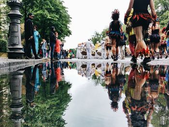 People standing by trees against sky