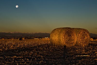 Scenic view of farm against sky during sunset