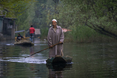 Man standing on lake against trees