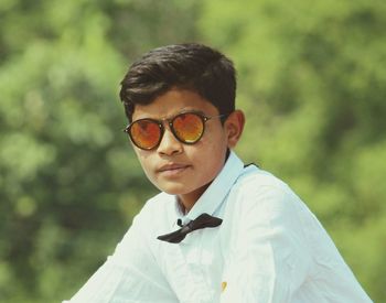 Portrait of teenage boy wearing sunglasses standing outdoors