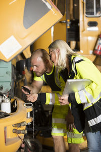 Colleagues working together repairing machines