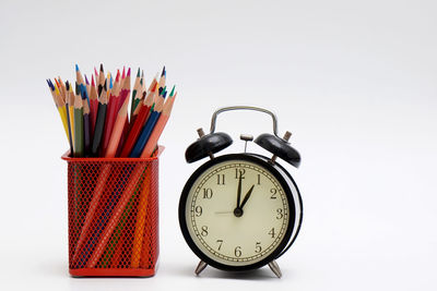 Close-up of clock on table against white background