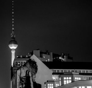 Low angle view of illuminated buildings and fernsehturm against sky at night