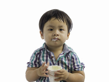 Portrait of boy drinking coffee against white background