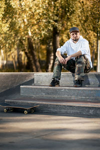 Portrait of man sitting on skateboard