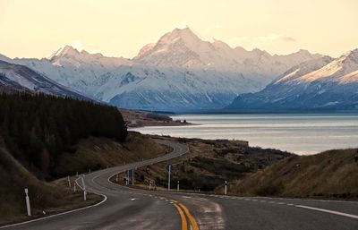 Road amidst snowcapped mountains against sky