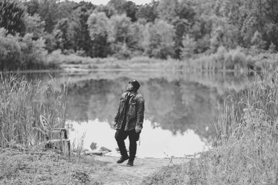 Rear view of man with dog walking in lake