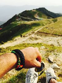 Low section of man on mountain against sky