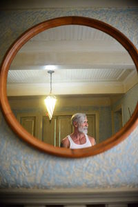 Low angle view of man reflected by the mirror 