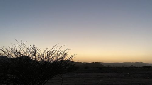Scenic view of silhouette land against clear sky during sunset