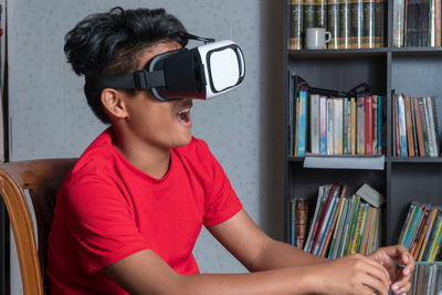 Boy gesturing while using virtual reality simulator