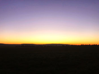 Scenic view of silhouette landscape against clear sky at sunset