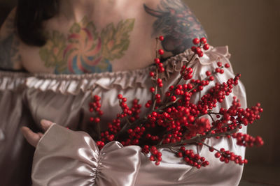 Close-up of woman with red flowers