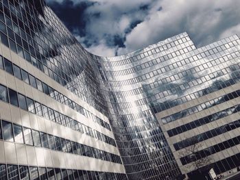 Low angle view of modern building against cloudy sky